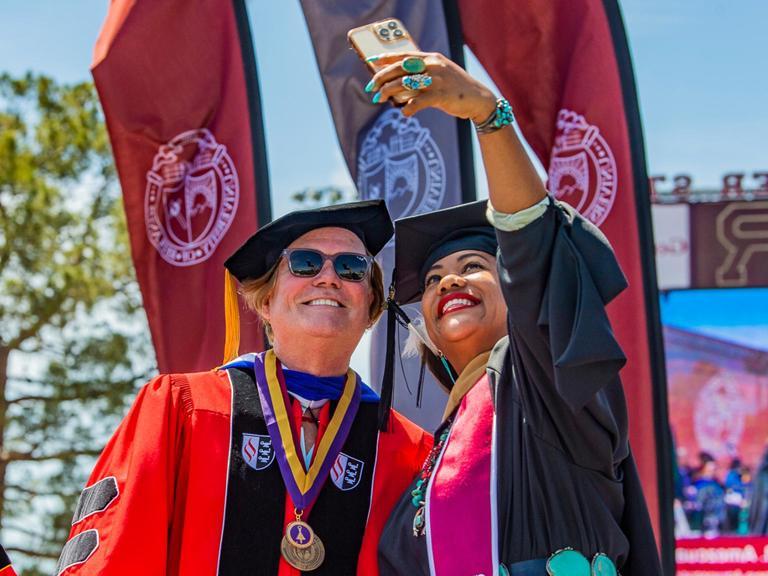 Image card - SBS graduate capturing selfie with Dean